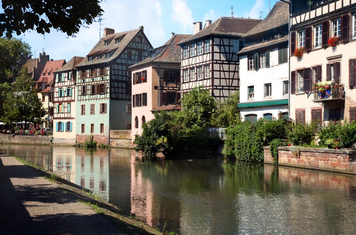 Façades colorées de maisons à colombages alsaciennes bordant un canal urbain