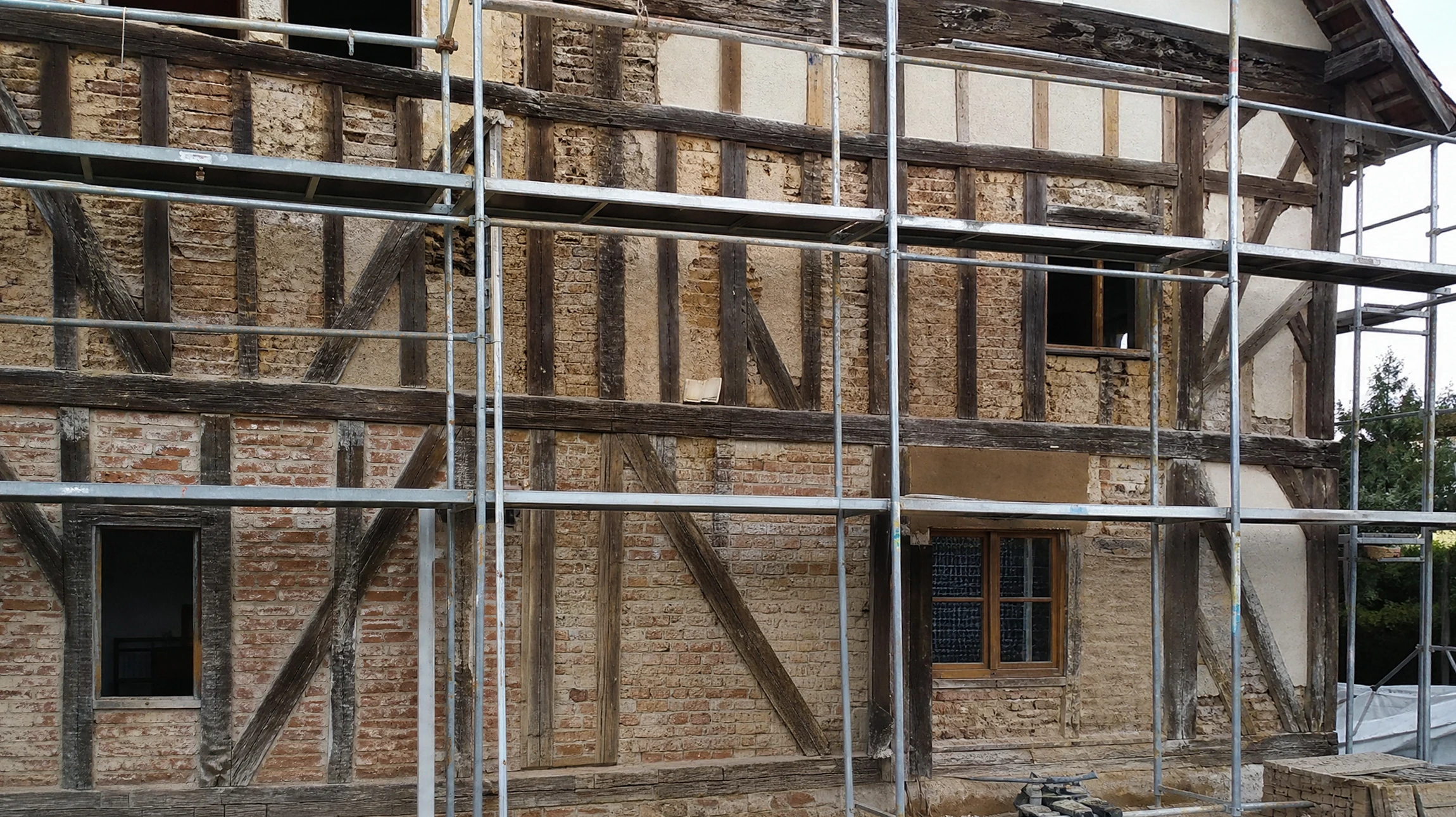 Ensemble de maisons à colombages traditionnelles allemandes avec toitures en tuiles terre cuite, façades blanches ornées de poutres apparentes en bois sombre formant motifs géométriques