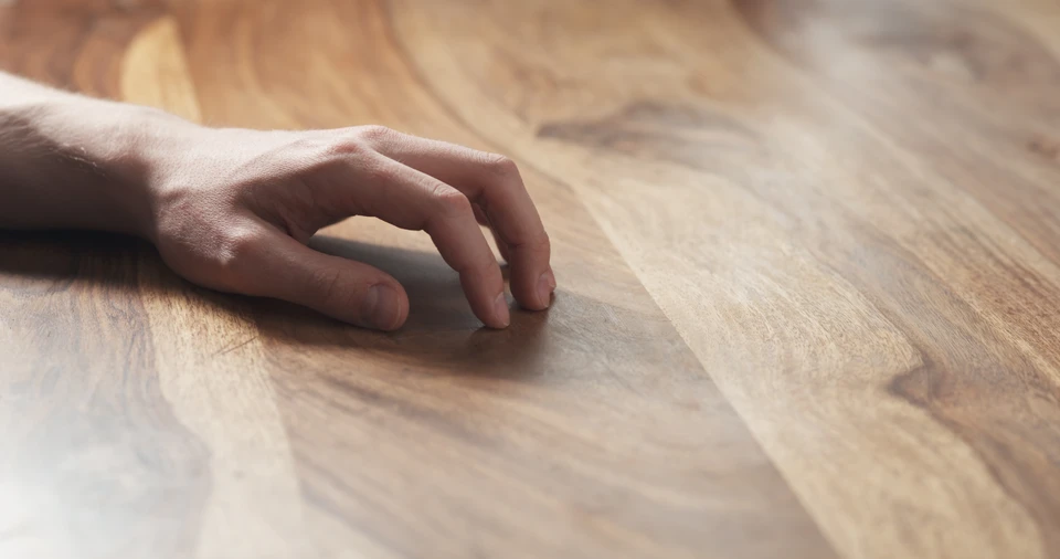 Artisan menuisier barbu souriant consulte une tablette numérique dans son atelier de menuiserie