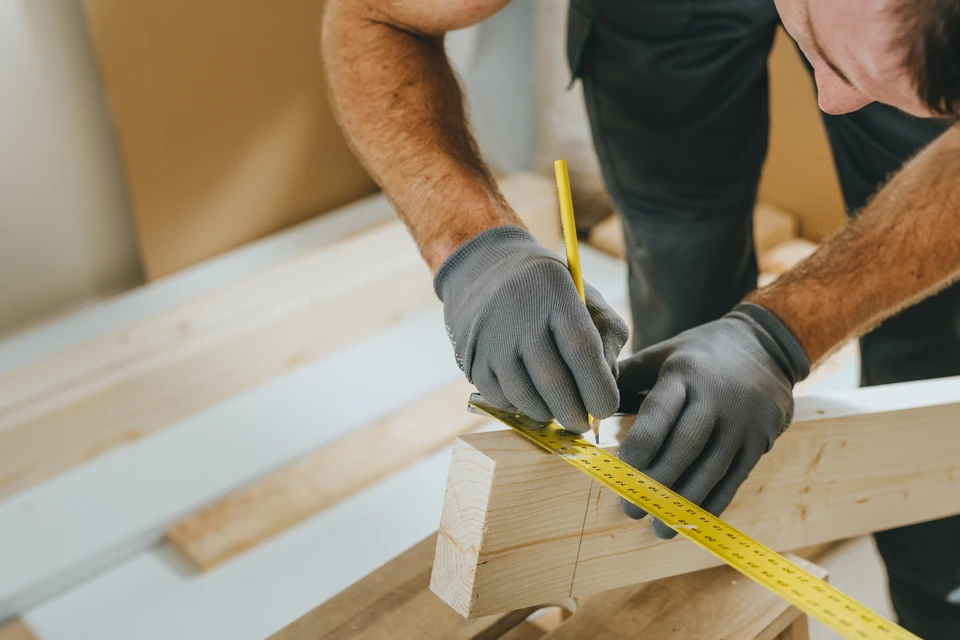 Atelier de menuiserie avec artisan concentré travaillant sur établi, portant protection auditive